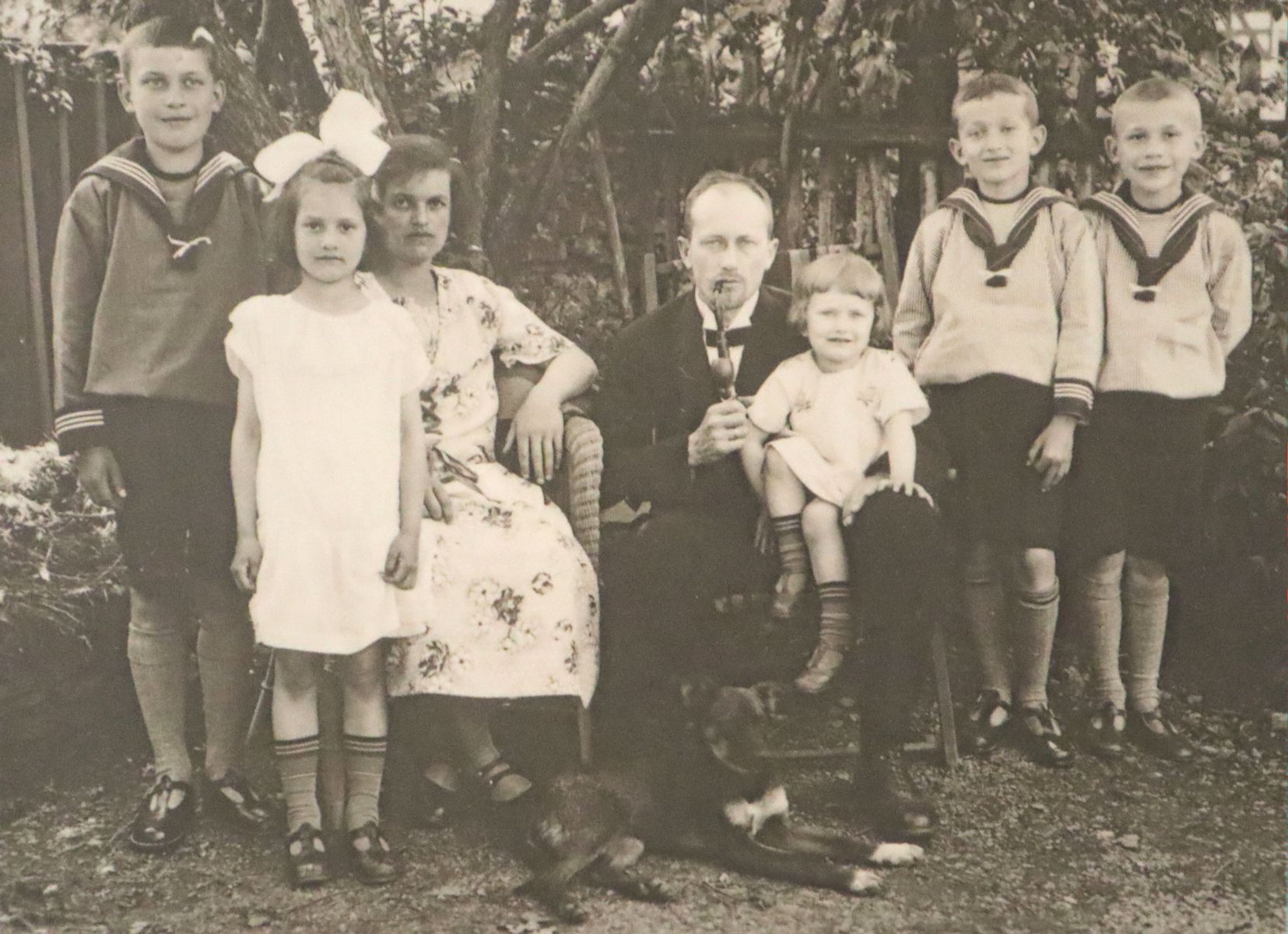 Stellbrink mit seiner Frau, seinen drei überlebenden Kindern und mit zwei Pflegesöhnen (ganz links und ganz rechts) um 1932, Bild in der Ausstellung in der Lutherkirche in Lübeck