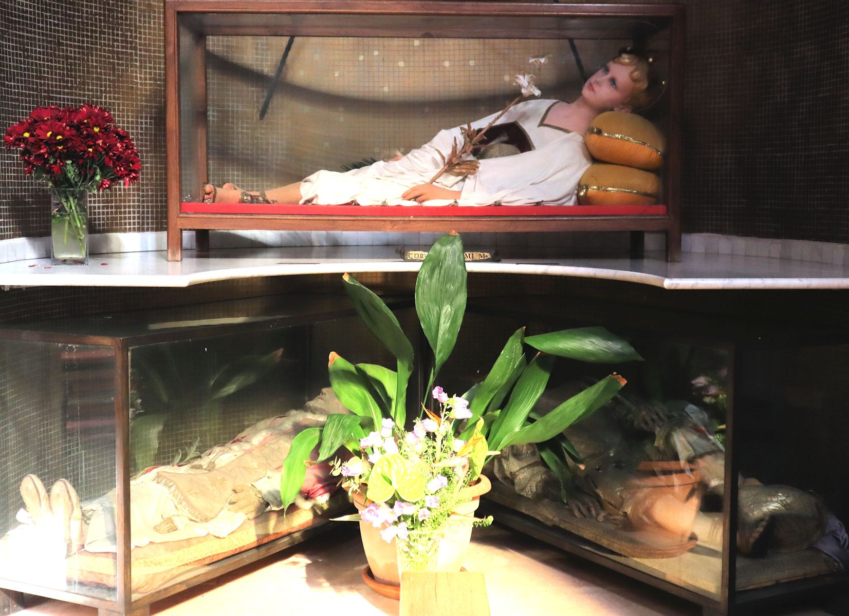 Primus-Liegefigur (oben) und die weiterer Märtyrer in der neuen Kirche San Nicola in Mentana