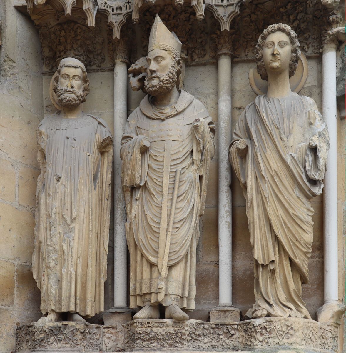 Statuen: Remigius (Mitte) mit einem Heiligen und einem Engel, um 1228, am rechten Nordportal der Kathedrale in Reims